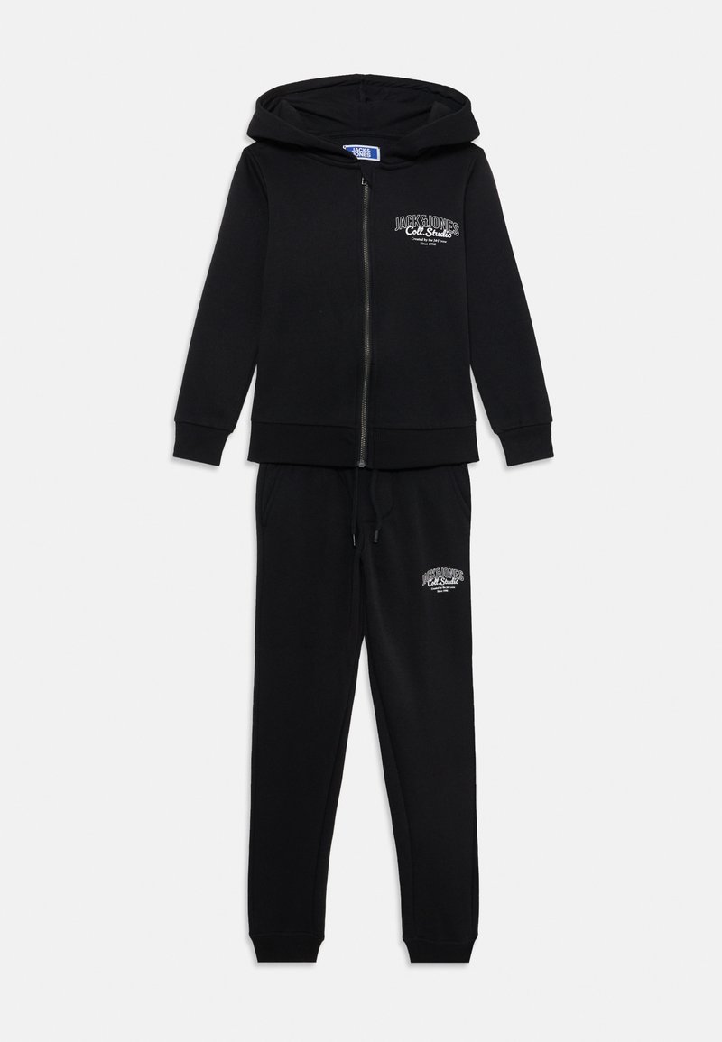 Black hoodie and sweatpants set in soft fabric, featuring a zip-up front, drawstring waist, and logo detail on the chest and leg.