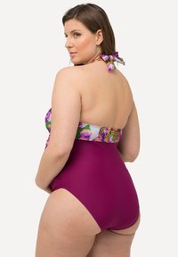 Plavky mají květinový vršek v fialových a zelených odstínech, krční uzel a jednobarevný magentový spodek s designem s vysokým vyříznutím.