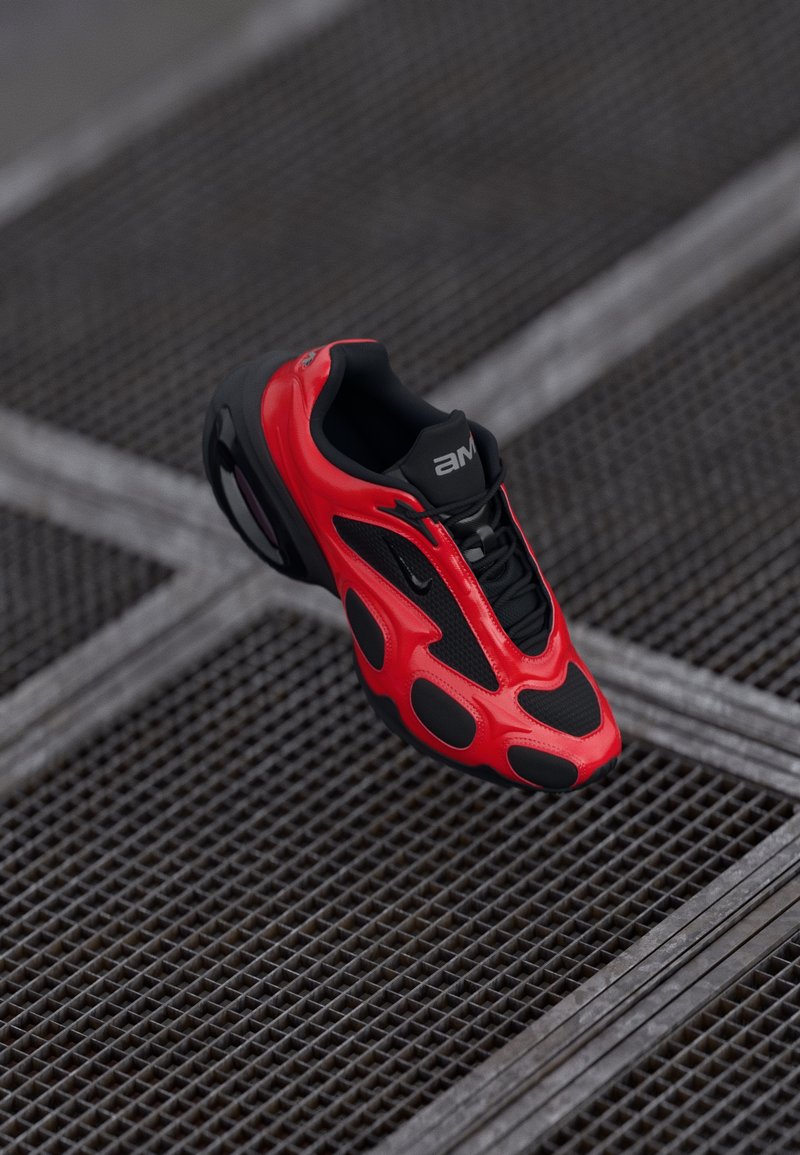 Sarkans sporta apavas ar elegantu dizainu, kas satur melnas sieta akcentus, redzamās auklas un gumijas zoli, novietots uz teksturētas fona.