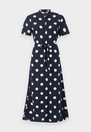 Μίντι φόρεμα σε ναυτικό μπλε χρώμα με λευκές πουά, με κοντά μανίκια, κουμπιά στο μπροστινό μέρος, γιακά και ζώνη στη μέση που δένει.