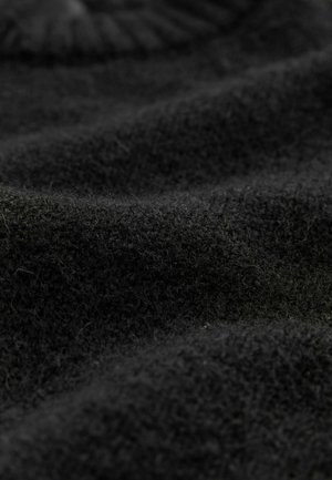 Schwarzer Wollstoff mit einer weichen, strukturierten Oberfläche, die feine Flauschigkeit und sanfte Falten zeigt und eine solide, dunkle Farbe betont.