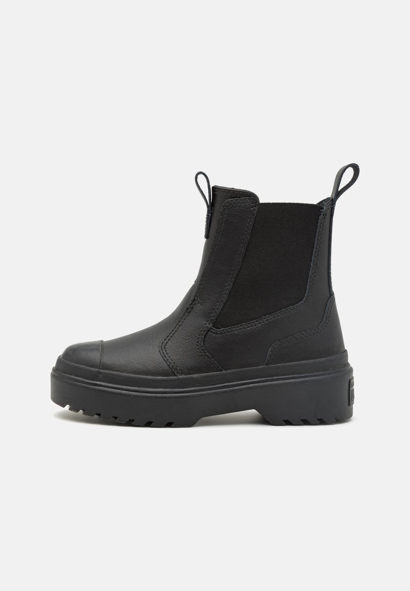 Botines negros de piel suave con paneles laterales elásticos, puntera redonda y suela de goma gruesa con un patrón de tracción.