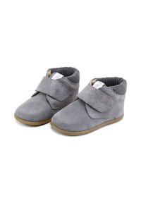 Zapatos de ante gris con punta redondeada, correa ajustable de Velcro y puño de tobillo con estrías. Suela de goma para agarre y durabilidad.