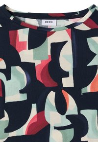 T-shirt à col rond avec des formes géométriques abstraites colorées en bleu marine, rouge, vert, orange et tons crème, avec une étiquette "CECIL" au niveau du col.