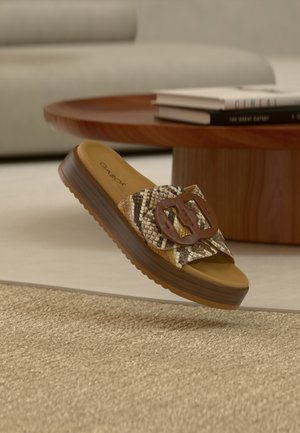 Sandale à enfiler avec tige texturée à imprimé serpent en beige et marron, une boucle marron en accent, et une semelle plateforme épaisse avec texture striée.