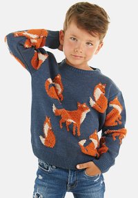 Blau gestrickter Pullover mit orangefarbenen und cremefarbenen Füchsen, die sich über die Ärmel und den Körper ziehen. Er hat einen gerippten Rundhalsausschnitt und gerippte Bündchen.