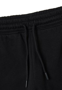 Pantaloni sportivi neri con vita regolabile, polsini elastici e materiale in cotone morbido. Design minimalista senza motivi o accentuazioni visibili.