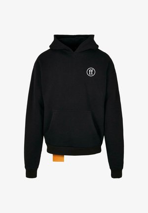 Sweat à capuche noir avec poche avant, petit logo circulaire blanc sur le côté gauche de la poitrine, et une petite étiquette orange suspendue à l'ourlet inférieur.