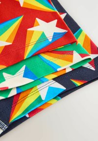 Šareni komadi tkanine s uzorcima zvijezda i duginih boja na crvenoj, zelenoj i tamnoplavoj pozadini, s glatkim teksturama i šavovima.