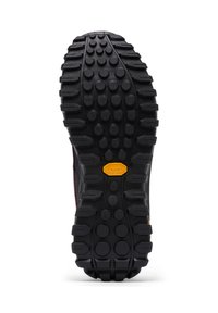 Vibram-pohja, jossa on teksturoitu musta kumipinta, jossa on pyöreitä kuvioita ja uria, jotka parantavat pitoa ja kestävyyttä.