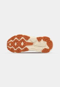 Running shoe sole with a mixed rubber design; features textured orange and beige traction patterns, with HOKA branding.