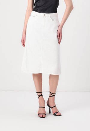 Hvit denim midi skjørt med rett snitt, front splitt og fem lommer, paret med svarte stroppehøyhælte sandaler.