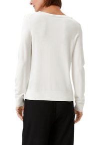 Biały dzianinowy sweter z długimi rękawami, okrągłym dekoltem oraz prążkowanymi mankietami i dołem. Miękka tekstura, dopasowany krój, minimalistyczny design.