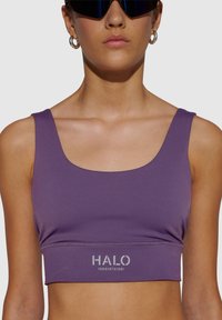 Lila crop top sportbh med fyrkantig halsringning och breda axelband. Har en silverfärgad "HALO"-logotyp nära nederkanten. Slät, elastisk tyg.