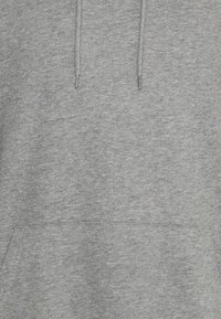 Felpa grigia con cappuccio realizzata in tessuto morbido, dotata di tasca frontale e cappuccio con cordino. Texture liscia con una finitura melangiata.