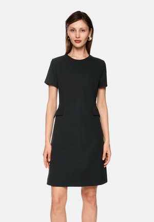 Black short-sleeve dress with a round neckline, structured design, side pockets, and a smooth, textured fabric finish.