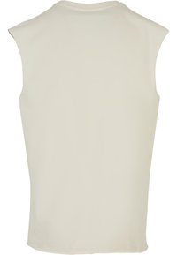 Udenærmet beige top med rund hals, lavet af glat stof. Har et rent design uden synlige mønstre eller accenter.
