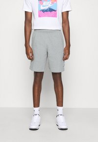 Gray cotton shorts with an elastic waistband and side pockets. Worn with a white t-shirt featuring a colorful Nike graphic.