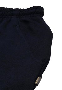 Marineblaue Jogginghosen mit einem elastischen Bund, seitlichen Taschen und einem kleinen Markenetikett an der Seite aus einem weichen, strukturierten Stoff.