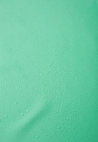 Υφή επιφάνειας σε μέντα πράσινο χρώμα με πολυάριθμες σταγόνες νερού, δημιουργώντας μια λεία, γυαλιστερή εμφάνιση. Η επιφάνεια είναι ελαφρώς τσαλακωμένη.