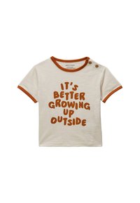 T-shirt pour tout-petit couleur crème avec des bordures orange, deux boutons à l'épaule et un texte marron indiquant "C'est mieux de grandir dehors."