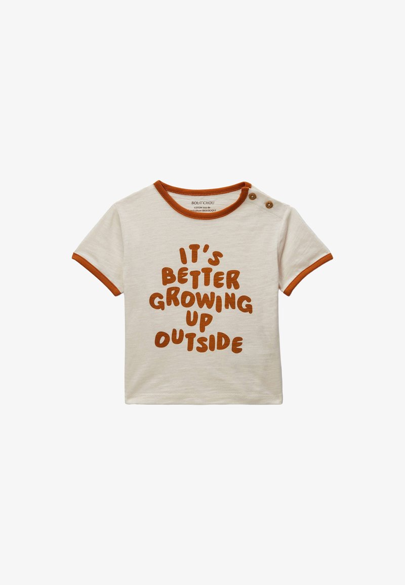 T-shirt pour tout-petit couleur crème avec des bordures orange, deux boutons à l'épaule et un texte marron indiquant "C'est mieux de grandir dehors."