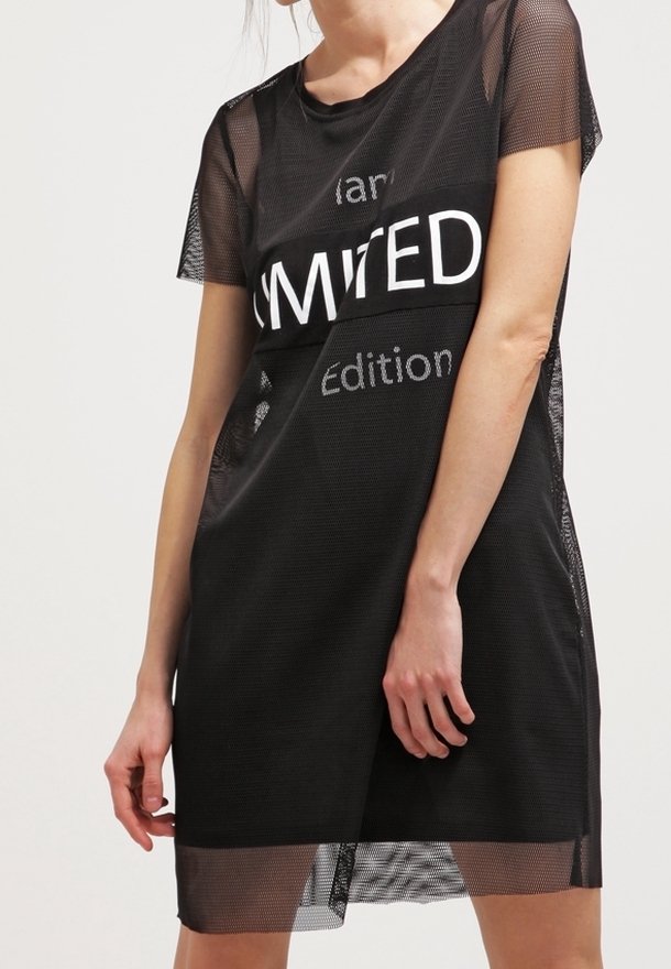 Svart meshklänning med korta ärmar, med fet vit text "LIMITED Edition" på framsidan. Löst sittande med en något genomskinlig textur.