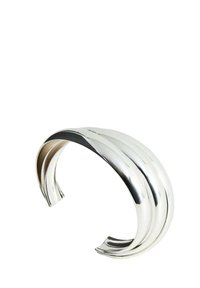 Bracciale cuff in metallo argentato con una finitura liscia e lucida. Presenta tre scanalature curve che corrono parallelamente lungo la sua superficie. Design aperto.