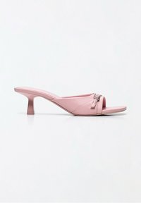 Mule rose à bout ouvert avec un petit talon et un détail de boucle sur fond blanc uni.