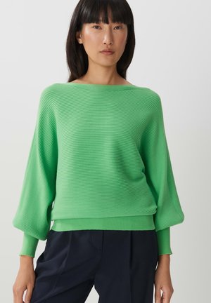 Grüner gerippter Strickpullover mit weitem Ausschnitt und lockeren, ballonförmigen Ärmeln, ausgestattet mit einem taillierten Saum und glatter Textur.