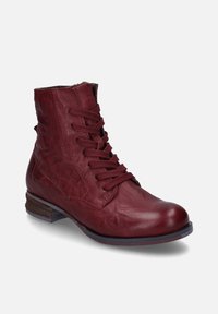 Botín de cuero rojo hasta el tobillo con punta redondeada, que presenta un diseño de cordones y un tacón bajo apilado. Textura suave con un brillo sutil.