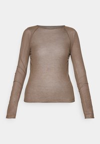 Pitkähihaisessa t-paidassa on vaaleanruskea sävy, se on valmistettu pehmeästä, ohkaisesta kankaasta, jossa on sileä pinta. Paidassa on pyöreä pääntie ja raglan-hihat.