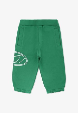 Pantalons de survêtement verts en tissu doux, avec une taille élastique, des poches latérales et un graphisme circulaire blanc sur la jambe gauche.