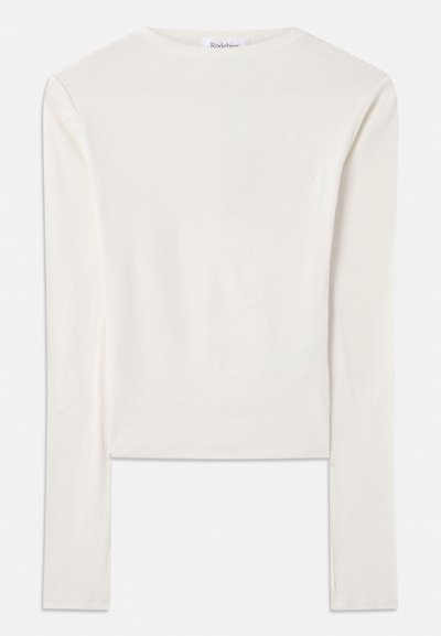 White long-sleeve top made of cotton, featuring a simple crew neck and a slim fit. The fabric is smooth with a slight stretch.