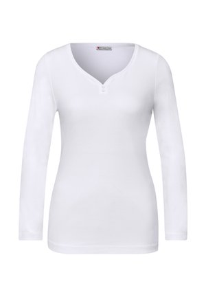 Biały top z długim rękawem wykonany z bawełny. Posiada dekolt w serek z dwoma guzikami. Gładka faktura, dopasowany krój, bez widocznych wzorów czy akcentów.