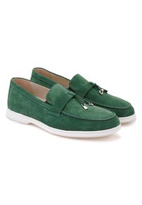 Green suede loafers with a slip-on design, featuring a decorative strap and metal accents, set on a white rubber sole.