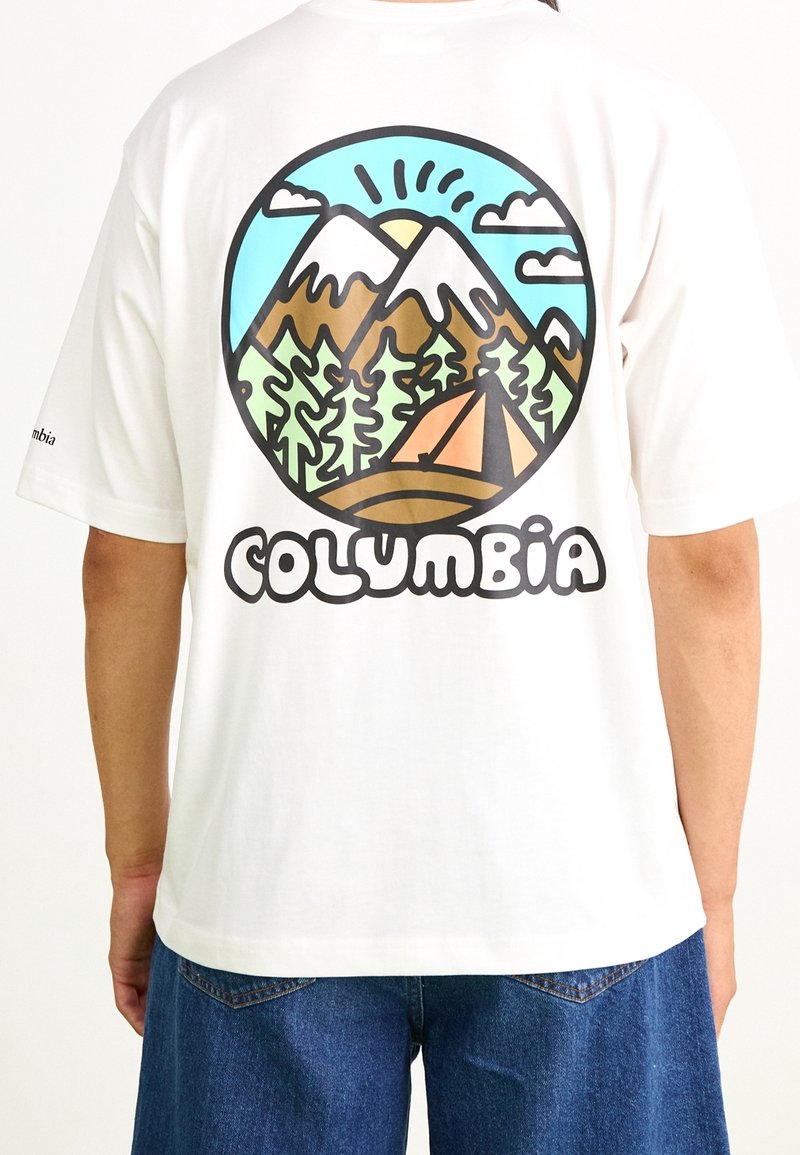Camiseta de algodón blanca con un gráfico colorido de montañas y bosque en la parte trasera. "COLUMBIA" está escrito en letras negras y en negrita debajo.