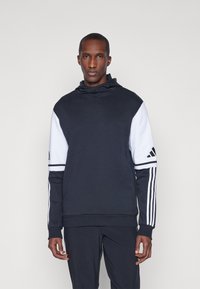 Sweatshirt à capuche bleu marine et blanc avec des poignets et un ourlet côtelés, une grande poche avant et un détail à trois bandes sur les manches.