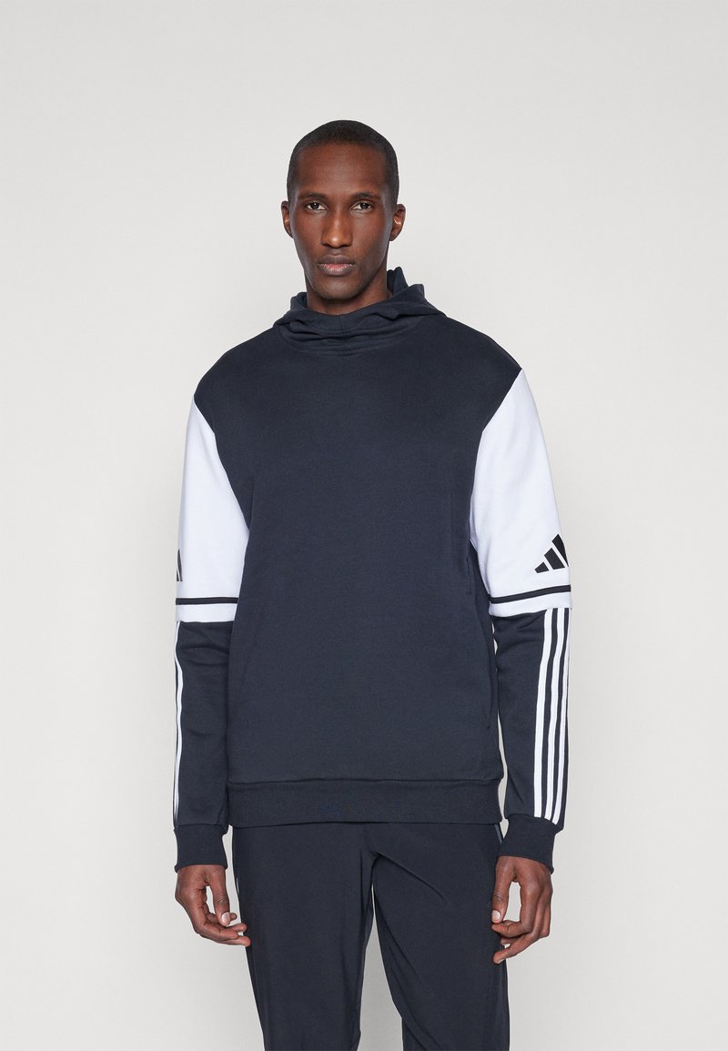 Sweatshirt à capuche bleu marine et blanc avec des poignets et un ourlet côtelés, une grande poche avant et un détail à trois bandes sur les manches.