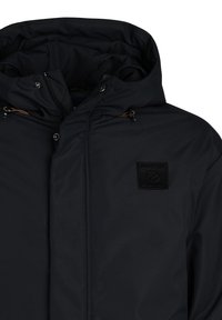 Chaqueta azul marino oscuro con capucha, con cierre de cremallera y un parche de logo texturizado en el pecho. Acentuada con cordones y botones de metal.