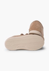 Chaussure en velours côtelé marron avec une tige texturée, bout rond et semelle en caoutchouc présentant un motif en vagues. Fabriqué en Espagne.
