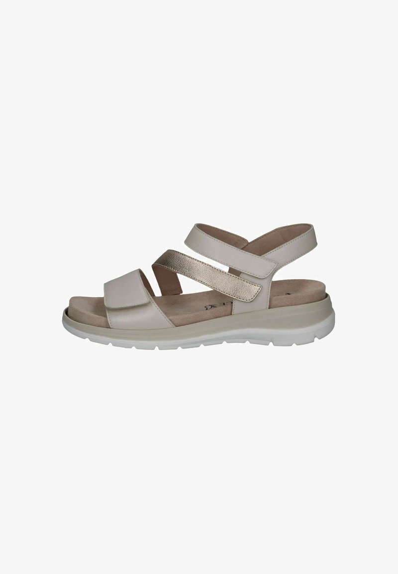 Sandales beiges avec deux brides croisées, une large bride avant, un accent métallique et une semelle rembourrée ; conçues pour le confort et la stabilité.