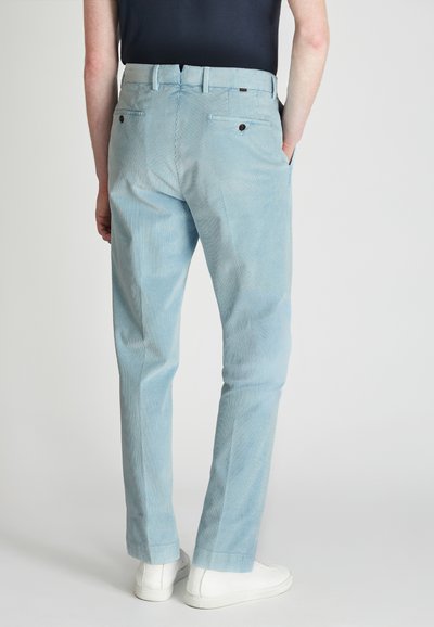 Lichtblauwe corduroy broek met een rechte snit, voorzien van twee achterzakken en een gestructureerd ribbelpatroon. G gecombineerd met witte sneakers.