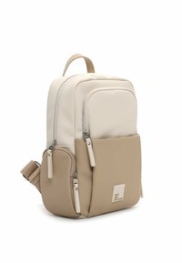 Beżowo-kremowy plecak o gładkiej teksturze, wyposażony w dwie przednie kieszenie na zamki oraz regulowany pasek. Minimalistyczny design z detalem w postaci logo.