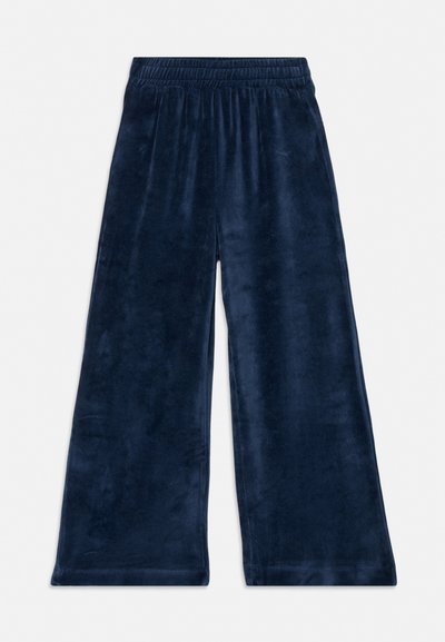 Tumesinised laia säärega veluurpüksid elastse vöökohaga, laotatud valgel taustal.