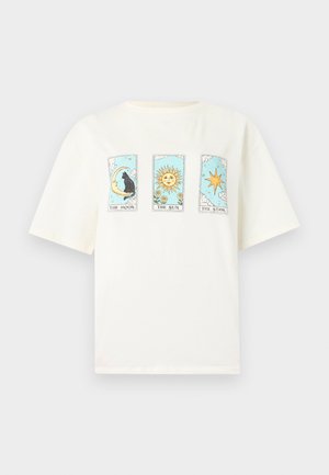 T-shirt blanc avec des motifs de cartes de tarot représentant un chat noir sur la lune, un soleil avec des tournesols et une étoile à huit branches sur un fond de ciel bleu.
