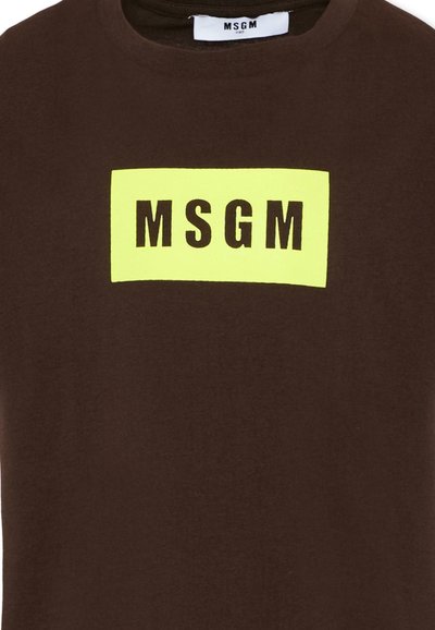 Camicia marrone scuro con una toppa rettangolare gialla brillante al centro del petto con la scritta nera in grassetto "MSGM".