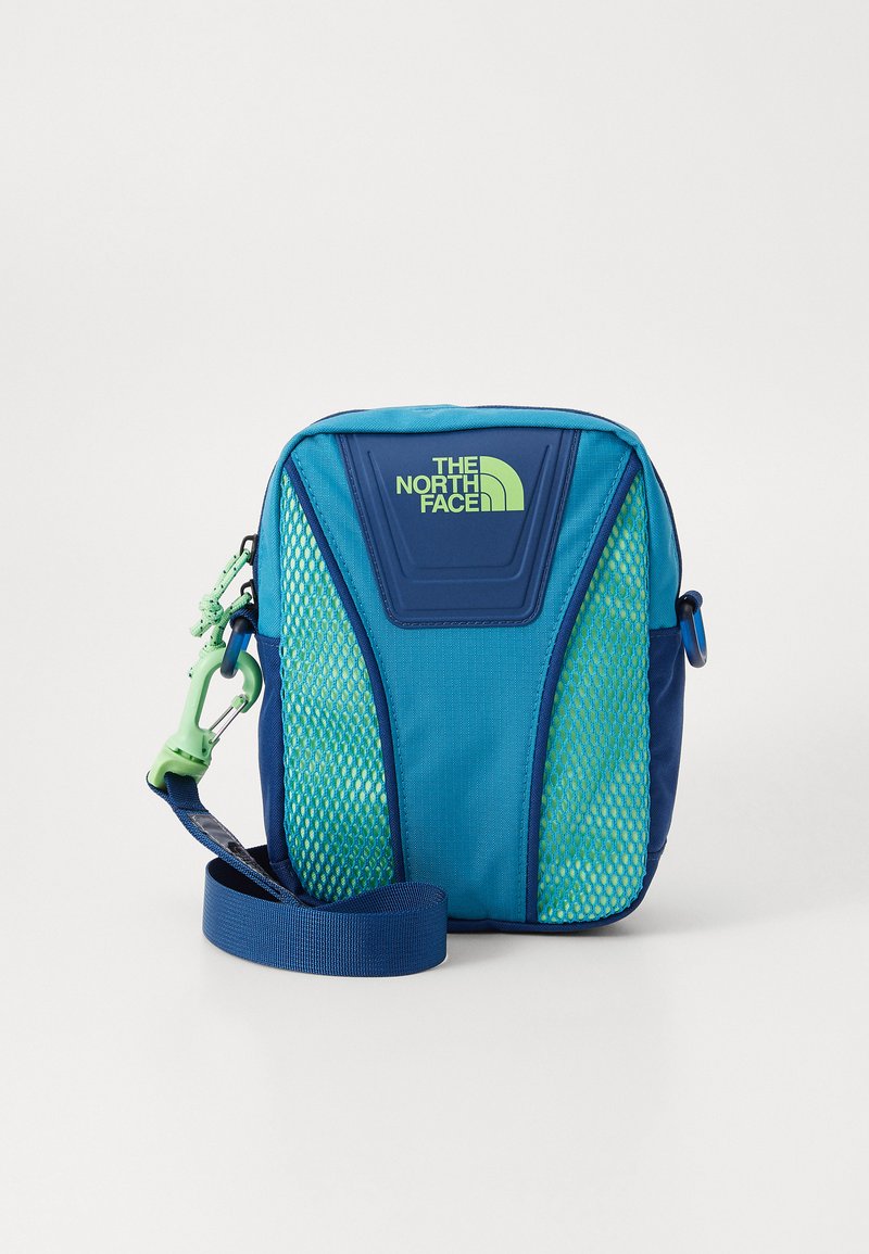 Niebieska i zielona torba na ramię z siateczkowymi panelami, regulowanym paskiem, logo 'The North Face' oraz wytrzymałym wykończeniem materiału. Wyposażona w klamrę karabinkową.