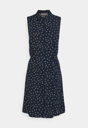 Ärmelloses navyblaues Kleid mit weißem kleinem Blumenmuster, vorn mit Knöpfen, Kragen und einem gebundenen Taillengürtel.