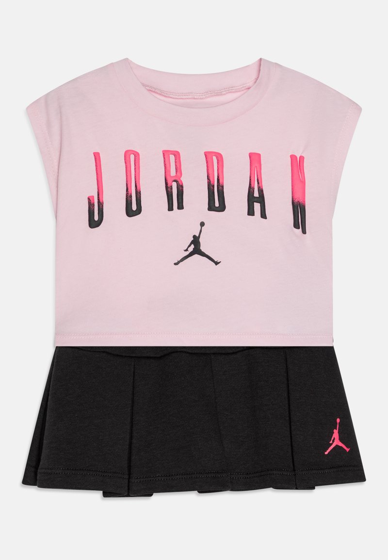 Světle růžový top bez rukávů s textem "JORDAN" ve gradientu černé a růžové. Černá plisovaná sukně s růžovým logem Jumpman. Směs bavlny.